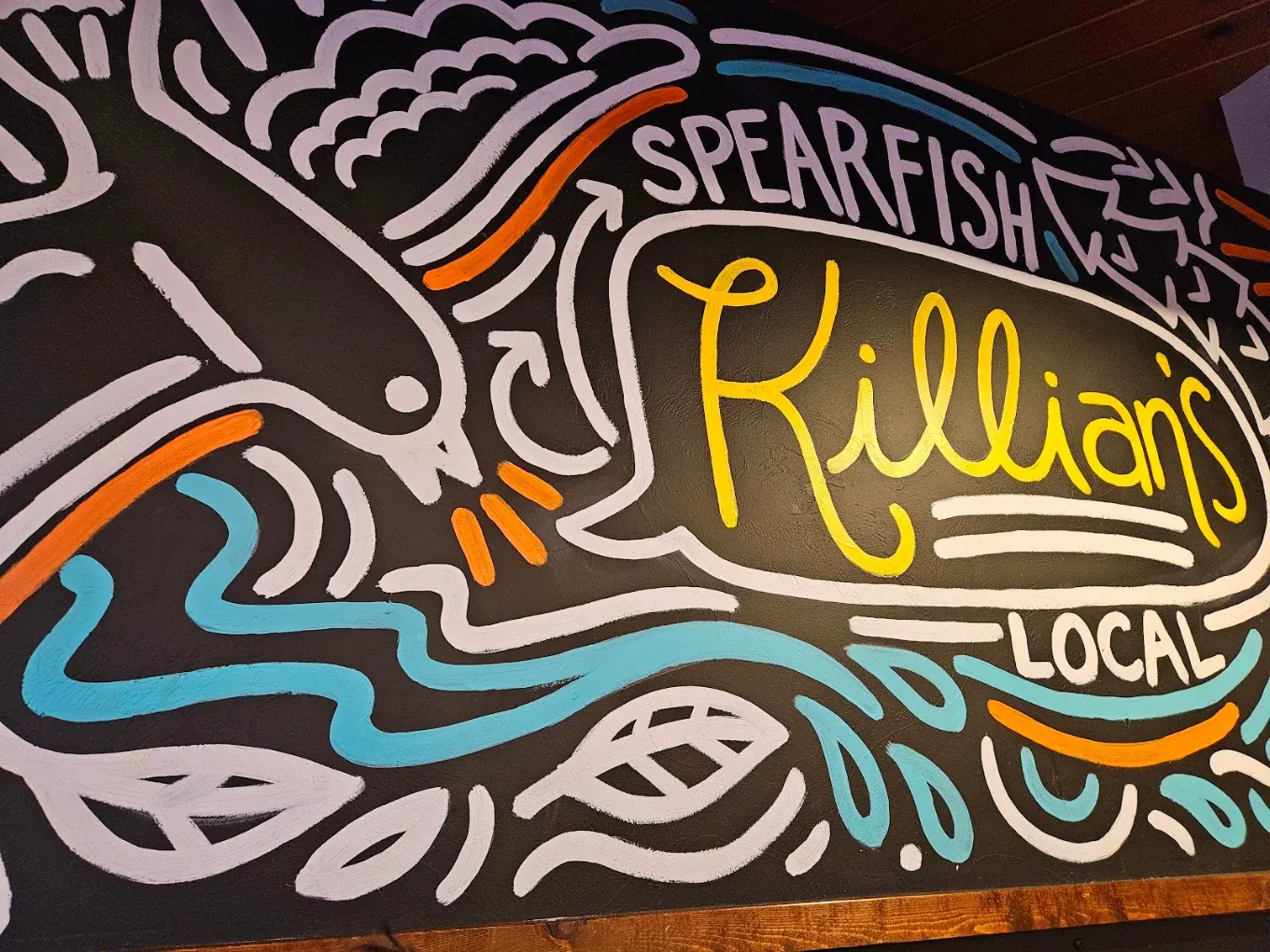 Hand-painted Spearfish Killian's Local mural with trout and river artwork inside the restaurant