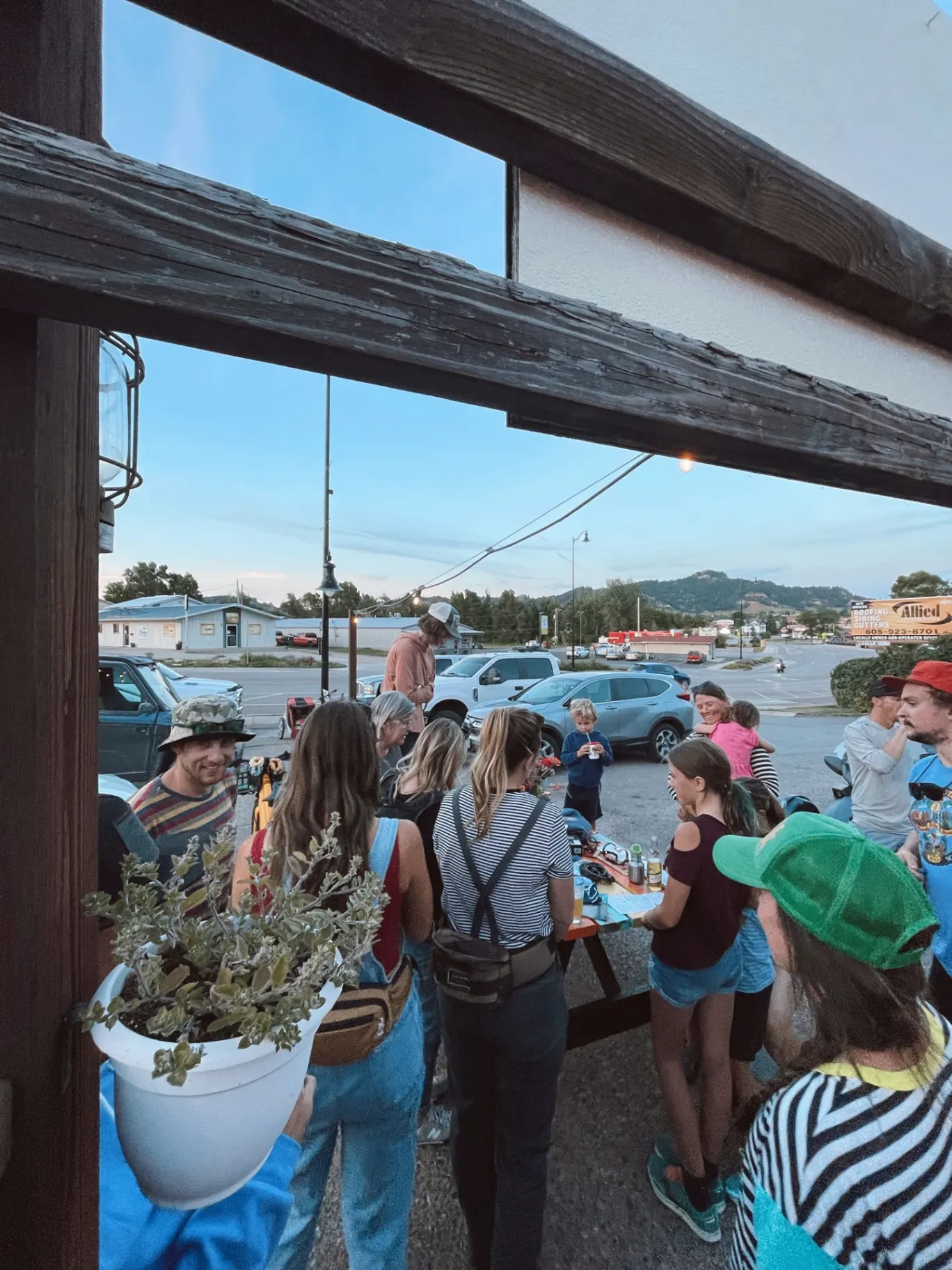 Guests gathered around picnic tables on the Killian's patio at dusk in Spearfish, Black Hills