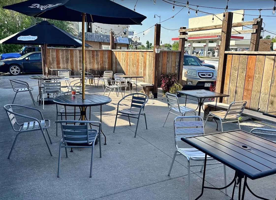 Sunny outdoor patio with umbrella tables and metal chairs at Killian's in downtown Spearfish
