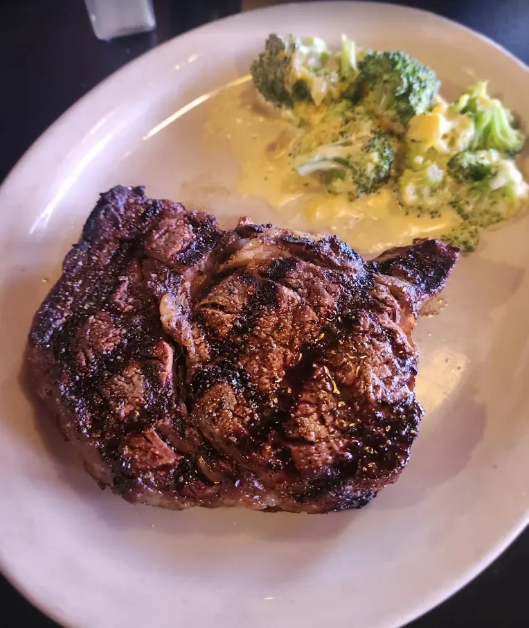 Char-grilled ribeye steak served with cheesy broccoli at Killian's steakhouse in Spearfish, Black Hills